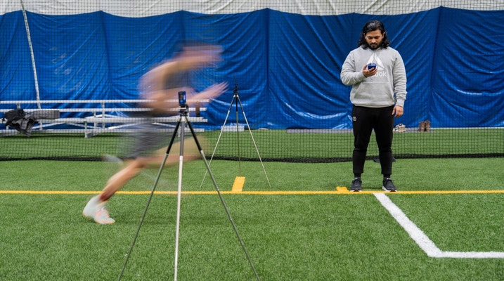 Image of person running fast with someone holding stopwatch 
